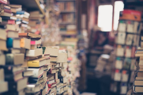 Old book store with piles of books stacked with Emma Tennant novels