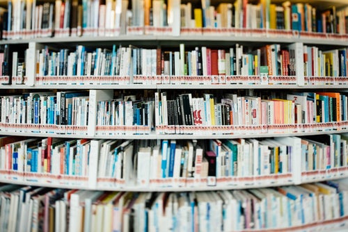 A densely packed library book shelf with novels by Nina Bawden displayed